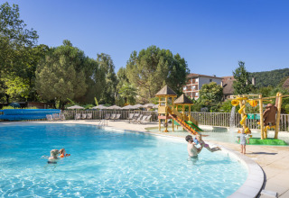 Familier nyder en udendørs swimmingpool med børneområde og legeplads på Huttopia Beaulieu sur Dordogne.