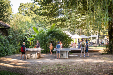 Kinder spielen draußen Tischtennis bei Huttopia Beaulieu sur Dordogne – Glamping Dordogne im Grünen.
