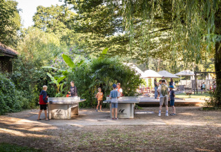 Kinder spielen draußen Tischtennis bei Huttopia Beaulieu sur Dordogne – Glamping Dordogne im Grünen.