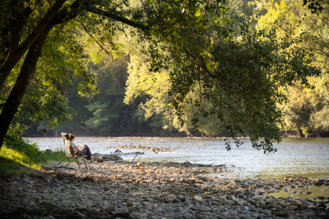 Relajándose junto al río en Huttopia Beaulieu sur Dordogne – Glamping Dordogne, rodeado de naturaleza.