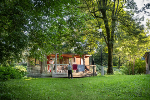 Alojamiento glamping en Huttopia Beaulieu sur Dordogne, con cabaña y entorno natural arbolado y verde.