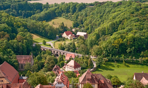Scenic view of Camping Schwabenmühle - Wijnvaten Baden-Württemberg nestled in lush, green hills and forest.
