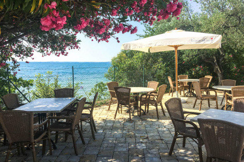 Buitenterras bij Sivinos Camping Boutique met uitzicht op het Gardameer, bloemen en parasols aanwezig.