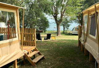 Alojamiento glamping con tiendas, sillas y caravana junto al lago en Sivinos Camping Boutique, Lago de Garda.
