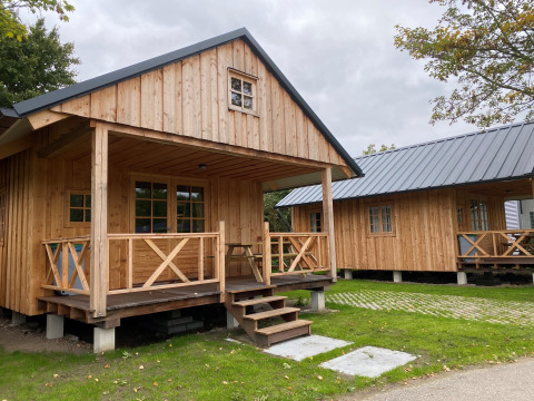 Due chalet in legno presso Camping & Chaletparc De Uitwijk – Lodges Noord-Brabant immersi nel verde.