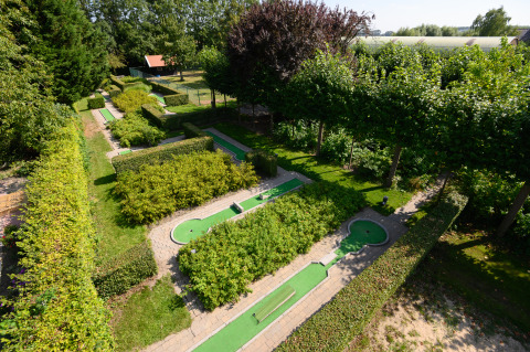 Mini-golf courses surrounded by lush hedges at Camping & Chaletparc De Uitwijk – Lodges Noord-Brabant.