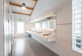 Helles, modernes Badezimmer mit mehreren Waschbecken bei Camping & Chaletparc De Uitwijk, Noord-Brabant.