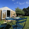 Outdoor dining table set up outside a glamping yurt at Camping La Ferme de Croas Men with green grass and trees.