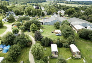 Vista aerea di Camping La Ferme de Croas Men con alloggi glamping, tende e aree verdi circostanti.