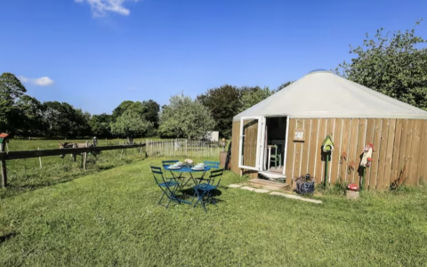 Udendørs billede af glamping på Camping La Ferme de Croas Men med en rund hytte og havebord i solskin.