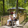 Two children, one in a wheelchair, on a ramp in front of an accessible glamping tent at Bio Vakantieoord.