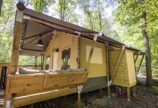 Glampingindkvartering i skoven hos Bio Vakantieoord - Glampingtenten Veluwe med træterrasse og natur.