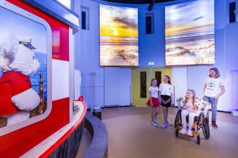 Des enfants s’amusent à l’intérieur du Bio Vakantieoord - Glampingtenten Veluwe près d’une expo d’ours.