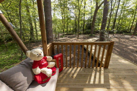 Glamping accommodation in the woods with teddy bear on terrace at Bio Vakantieoord - Glampingtenten Veluwe.