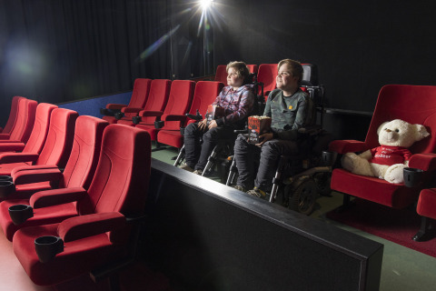 Twee kinderen in een rolstoel kijken een film bij Bio Vakantieoord - Glampingtenten Veluwe bioscoop.