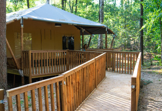 Glampingtent van Bio Vakantieoord - Glampingtenten Veluwe met toegangshelling in een bosrijke omgeving.
