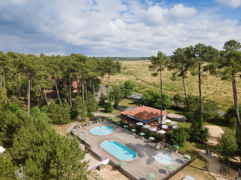 Aerial view of Huttopia Landes Sud - Glamping Aquitaine featuring pools, deck, patio, and forest surroundings.