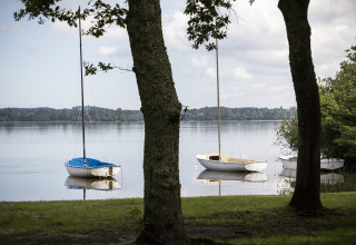 Zeilbootjes op het rustige meer bij Huttopia Landes Sud - Glamping Aquitaine omringd door natuur.