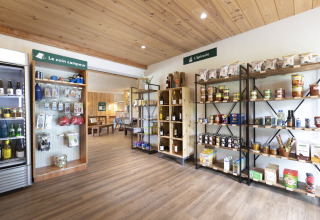 Winkel met levensmiddelen en kampeerartikelen bij Huttopia Landes Sud - Glamping Aquitaine, houten interieur.