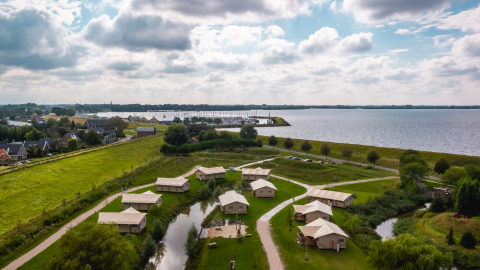 Luftaufnahme von Safarilodges im Vakantiepark IJsselhof in Noord-Holland am See mit Natur und Wegen.