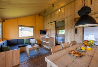 Interieur van glamping accommodatie in Vakantiepark IJsselhof - Safarilodges Noord-Holland met houten meubilair.