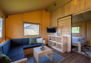 Alojamiento glamping moderno en Safarilodges de Vakantiepark IJsselhof, con muebles de madera y ambiente acogedor.