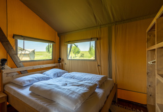 Glamping accommodatie bij Vakantiepark IJsselhof - Safarilodges Noord-Holland met comfortabel bed en uitzicht.
