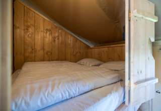 Knusse slaapruimte in houten lodge bij Vakantiepark IJsselhof - Safarilodges, Noord-Holland, glamping.