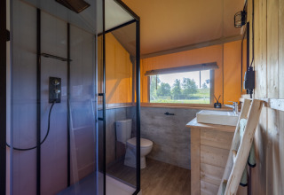 Badkamer van glampingaccommodatie bij Vakantiepark IJsselhof Safarilodges Noord-Holland met buitenzicht.