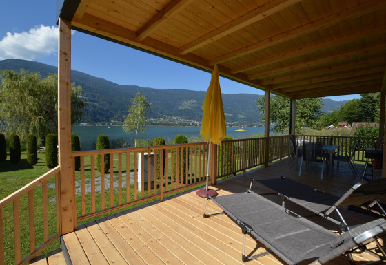 Houten terras met uitzicht op meer en bergen bij Terrassencamping Ossiacher See - Stacaravans Karinthië.
