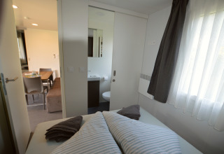 Chambre, salle de bain et coin repas dans un logement glamping au Terrassencamping Ossiacher See.