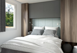 Modern glamping bedroom with cozy grey bedding and wood decor at Terrassencamping Ossiacher See.