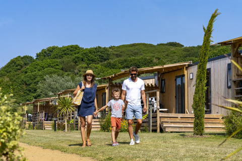 Gezin wandelt voor glampingaccommodaties te midden van natuur op Camping Saint Pabu Plage - Glamping Bretagne.