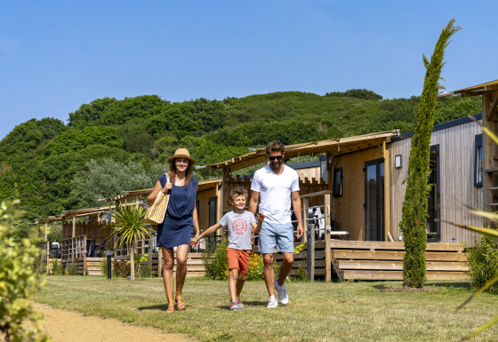 Gezin wandelt voor glampingaccommodaties te midden van natuur op Camping Saint Pabu Plage - Glamping Bretagne.
