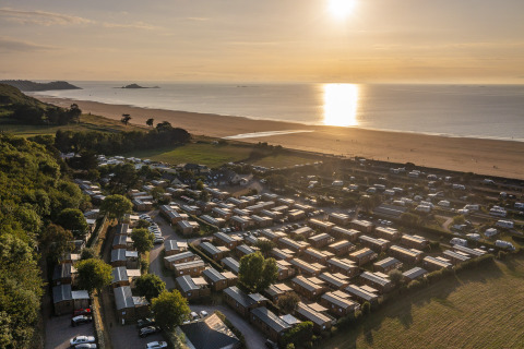Luchtfoto van glamping en camping bij Camping Saint Pabu Plage - Glamping Bretagne aan het strand bij zonsondergang.