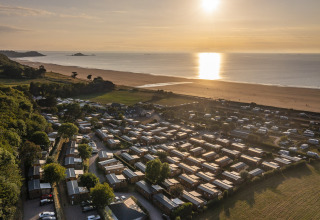 Luchtfoto van glamping en camping bij Camping Saint Pabu Plage - Glamping Bretagne aan het strand bij zonsondergang.