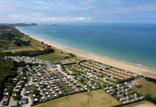 Luchtfoto van Camping Saint Pabu Plage - Glamping Bretagne aan een lang zandstrand aan de fraaie kustlijn.