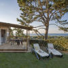 Glamping accommodation with wooden terrace, loungers and sea view at Camping Saint Pabu Plage - Glamping Bretagne.