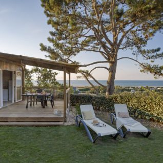 Glamping-Unterkunft mit Holzterrasse, Liegen und Meerblick bei Camping Saint Pabu Plage - Glamping Bretagne.