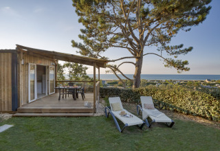 Glamping-Unterkunft mit Holzterrasse, Liegen und Meerblick bei Camping Saint Pabu Plage - Glamping Bretagne.