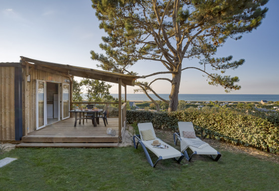 Alloggio glamping con terrazza in legno, lettini e vista mare presso Camping Saint Pabu Plage - Glamping Bretagne.
