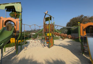 Playground with slides, climbing frames and sand at Camping Saint Pabu Plage - Glamping Bretagne.
