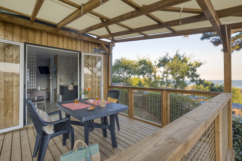 Hébergement glamping au Camping Saint Pabu Plage - Glamping Bretagne avec terrasse en bois et vue sur la mer.