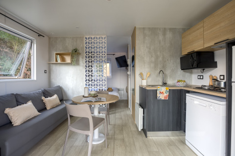 Moderne glampingindkvartering på Camping Saint Pabu Plage med køkken, stue og natulig belysning.