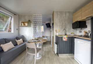 Moderne glampingindkvartering på Camping Saint Pabu Plage med køkken, stue og natulig belysning.