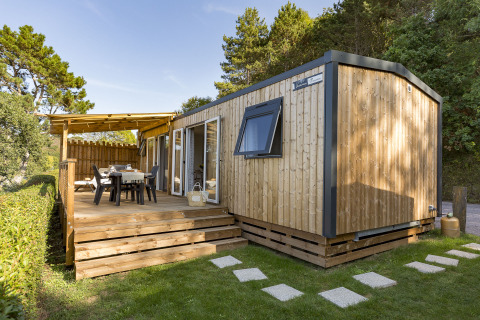 Moderne Glamping-Unterkunft mit Holzterrasse und Esstisch, Camping Saint Pabu Plage, Glamping Bretagne.