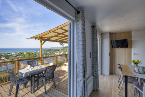 Alojamiento glamping moderno en Camping Saint Pabu Plage, Bretaña, con terraza y vista al mar.