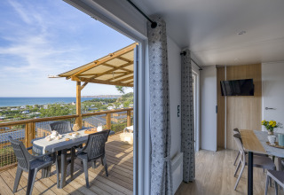 Terrasse mit Meerblick und stilvollem Glamping-Unterkunft bei Camping Saint Pabu Plage in der Bretagne.