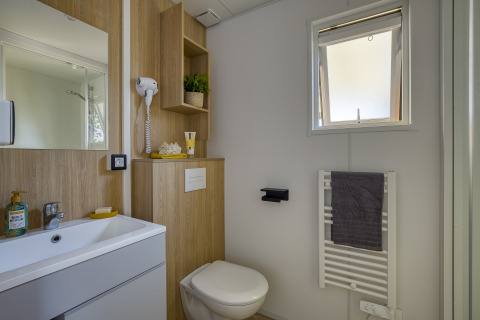 Modernes Badezimmer in der Glamping-Unterkunft Camping Saint Pabu Plage mit Holzdetails und Fenster.