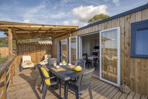 Terrasse mit Esstisch und Liegestühlen bei Camping Saint Pabu Plage - Glamping Bretagne, Frankreich.